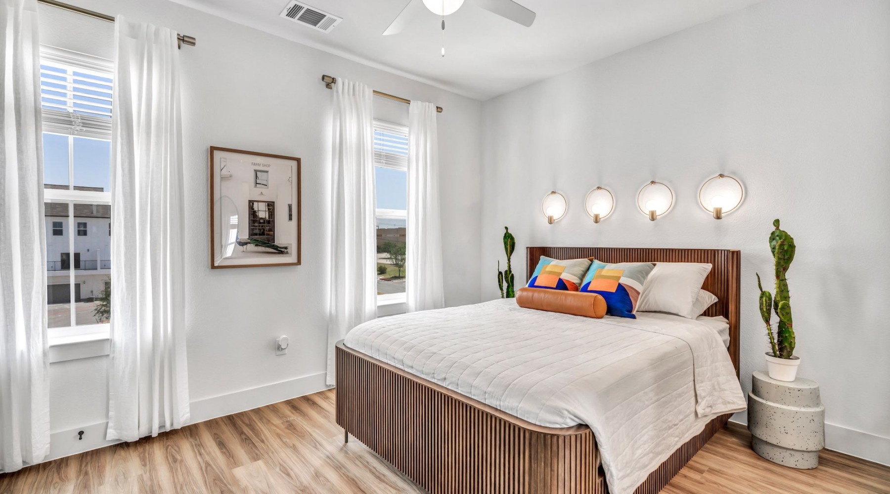a bedroom with a bed and a plant on the side